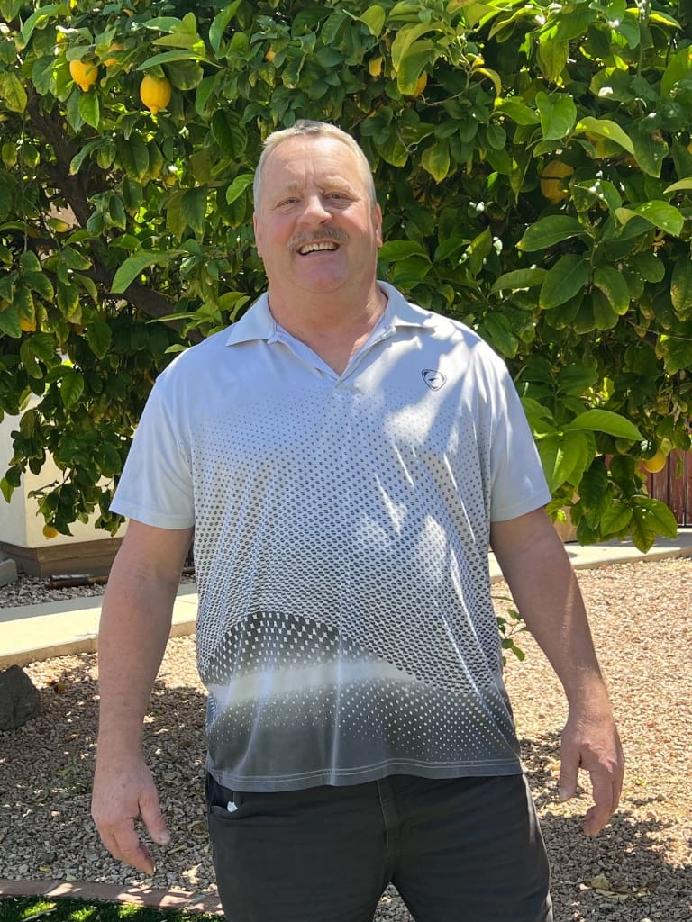 A man standing in front of some trees